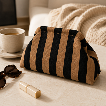 Black and gold striped cosmetic pouch on a vanity